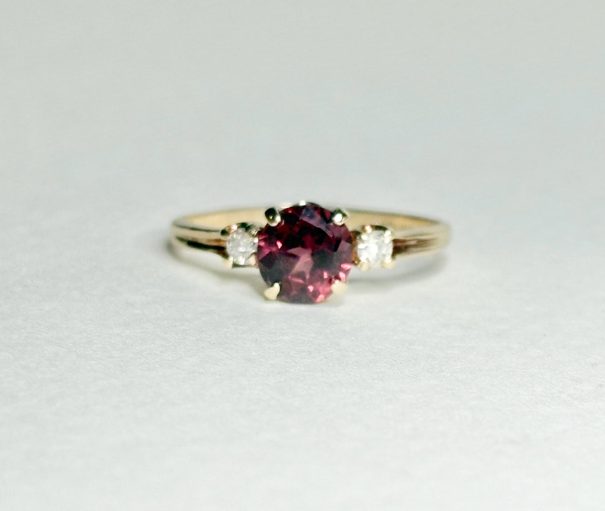 A 10k gold ring with a merlot garnet and two diamonds.