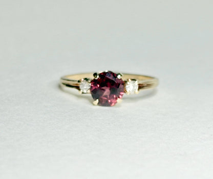 A 10k gold ring with a merlot garnet and two diamonds.