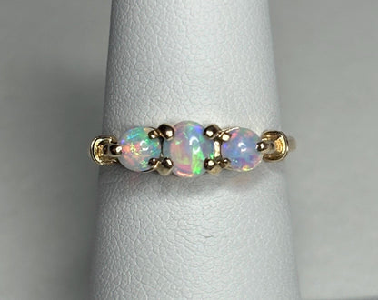 A 14k gold ring with three oval opals.