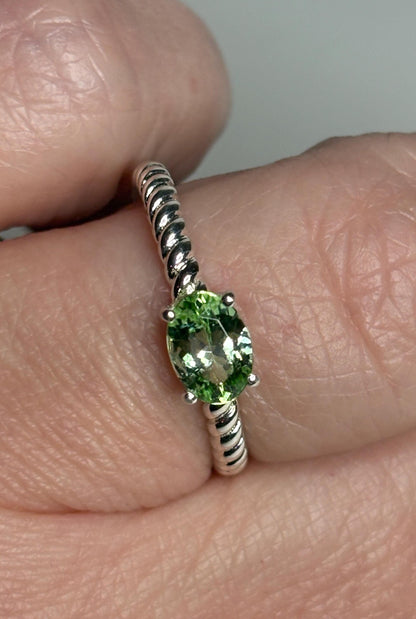 Sterling silver ring with an oval green tourmaline solitaire on a rope band.