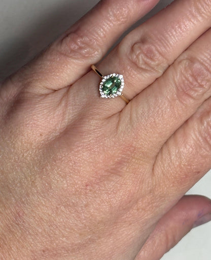 A mint green kyanite and zircon halo ring in solid 9k gold.