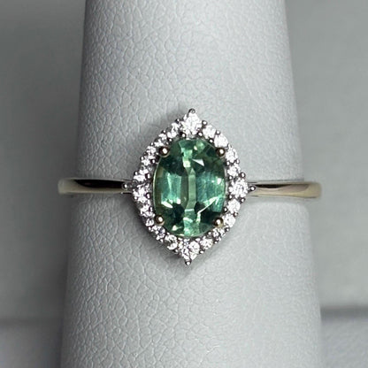 A mint green kyanite ring with a zircon halo in 9k gold.