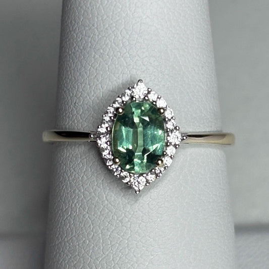 A mint green kyanite ring with a zircon halo in 9k gold.