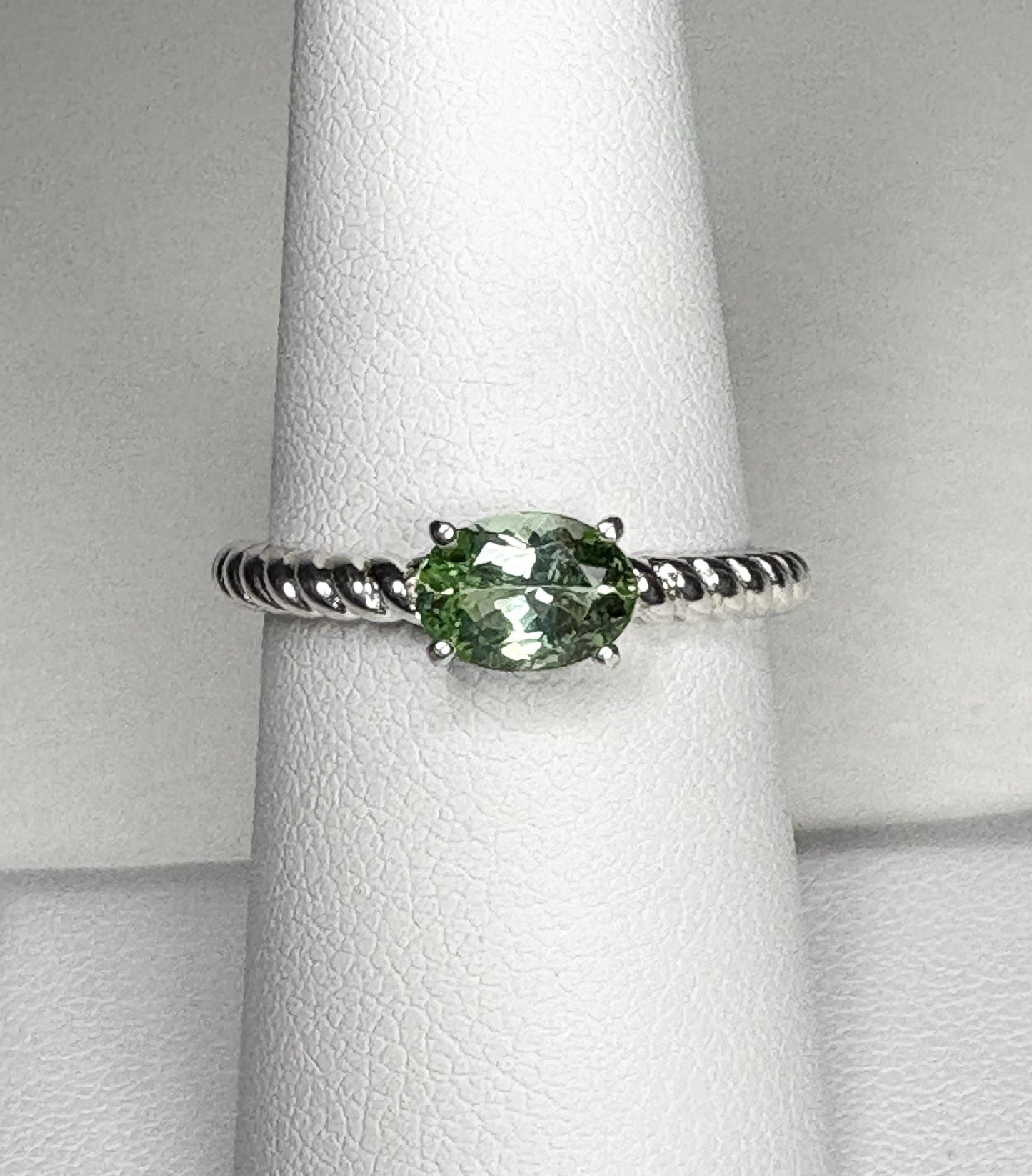 Sterling silver ring with an oval green tourmaline gemstone set east-west on a rope band.
