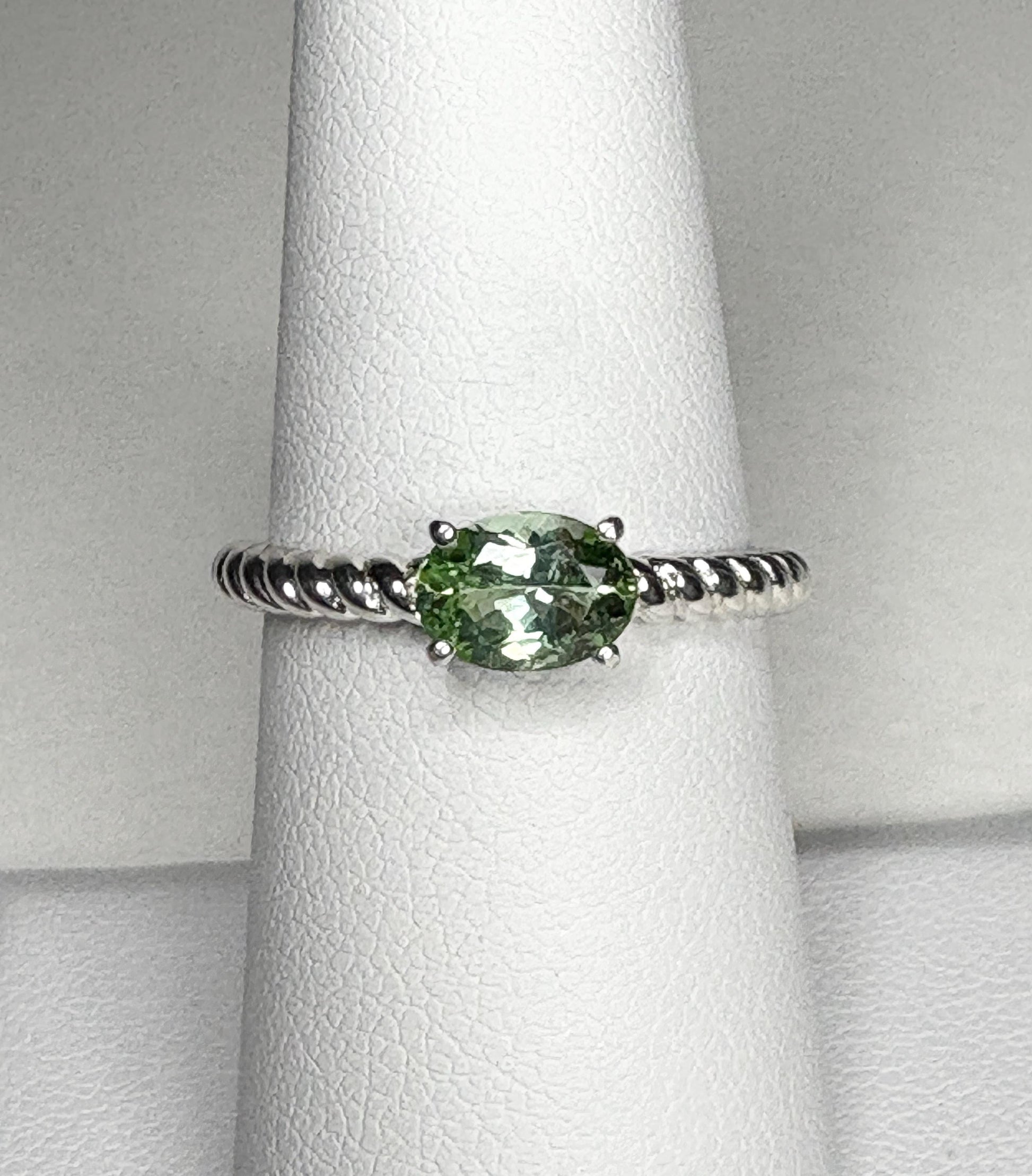 Sterling silver ring with an oval green tourmaline gemstone set east-west on a rope band.