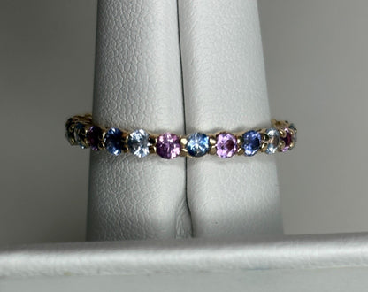 14k gold eternity band with alternating blue, pink, and violet sapphires.