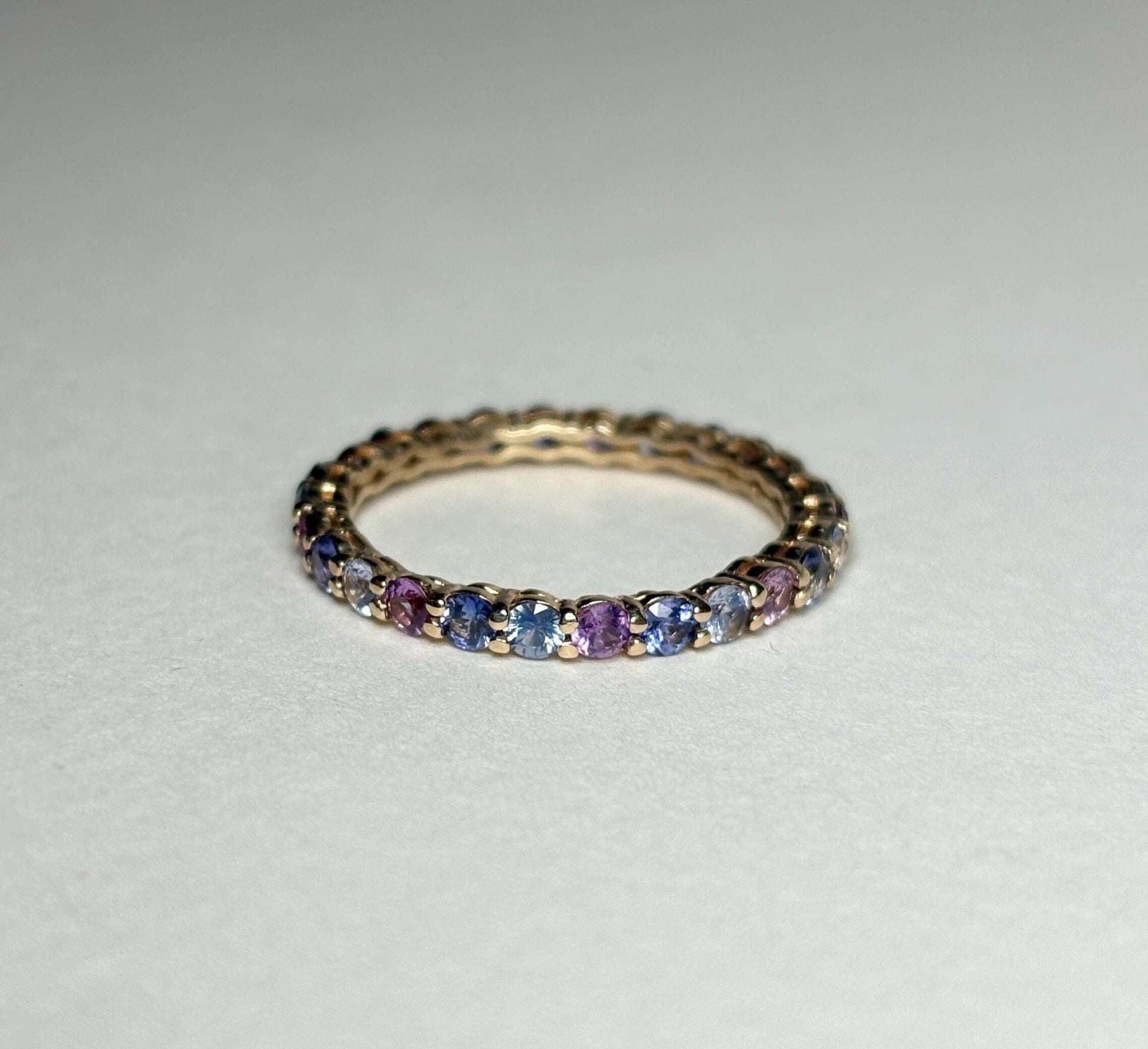14k yellow gold eternity band with multi-color sapphires.