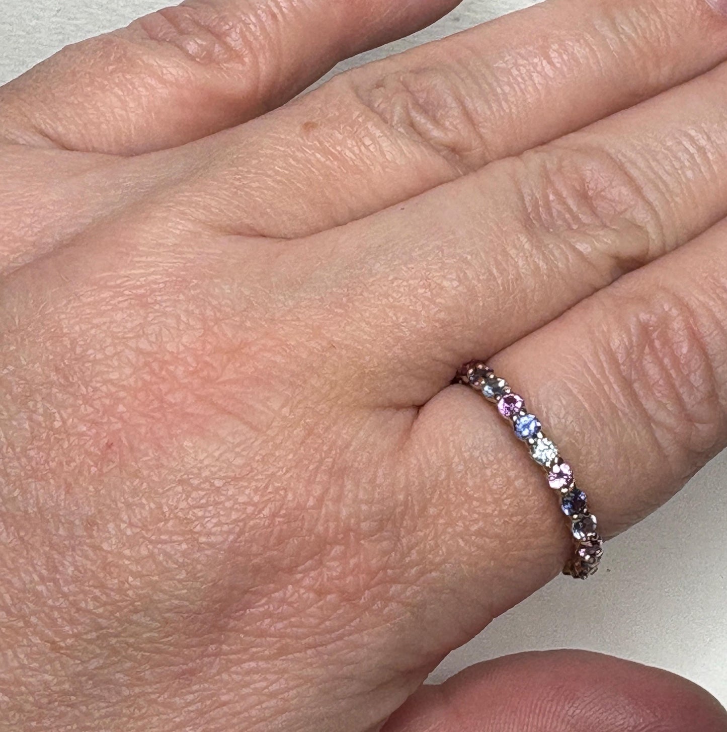 14k gold eternity band with multi-color sapphires.