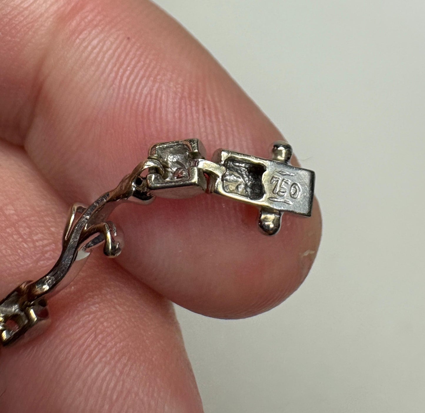 Solid 18k white gold bracelet with diamond vine links and a clasp marked 750.