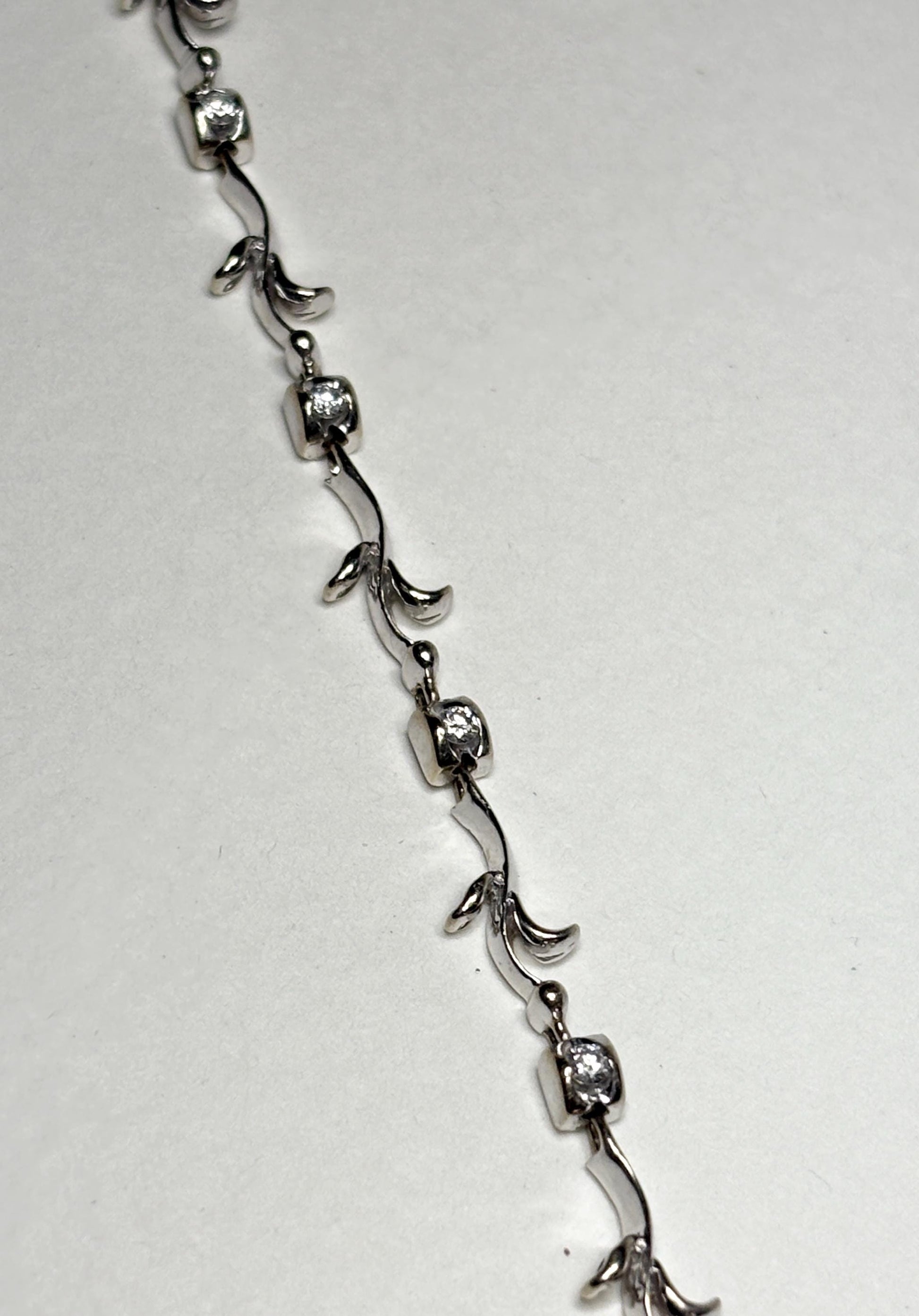 Solid 18k white gold bracelet with eleven natural diamonds and vine-like links.