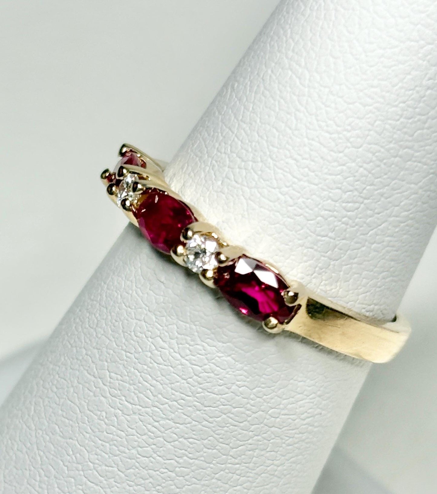 A 14k gold band ring with oval red sapphires and diamonds.