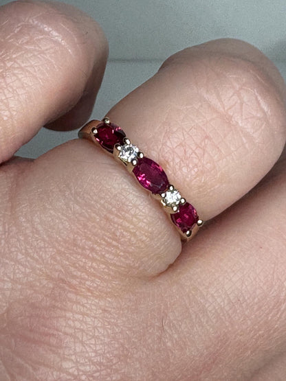 A 14k gold band ring with oval red sapphires and diamonds.