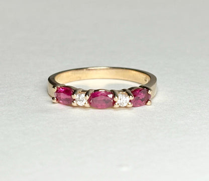A 14k gold band ring with oval rubies and diamonds.