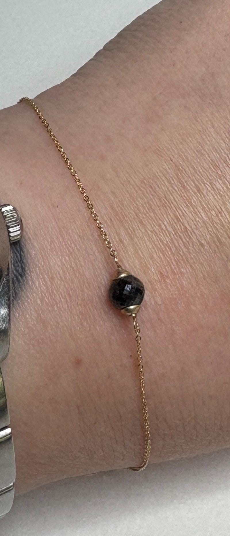 14k gold bracelet with a faceted black diamond bead.