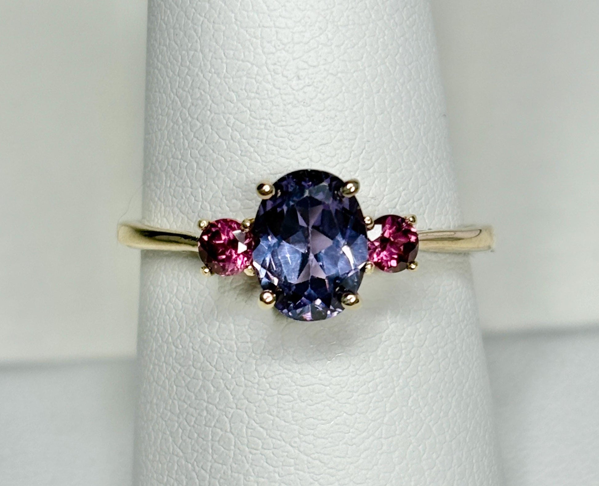10k gold ring with a color-changing synthetic sapphire and two umbalite garnets.