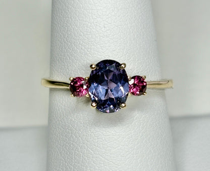 10k gold ring with a color-changing synthetic sapphire and two umbalite garnets.