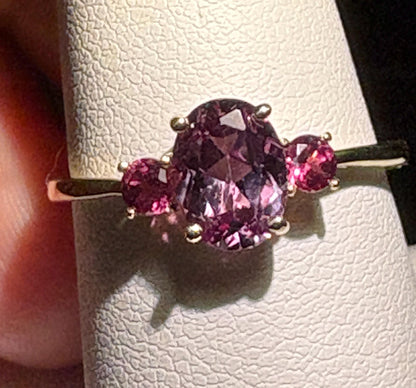 Ring with oval color change synthetic sapphire and two umbalite garnets in gold.