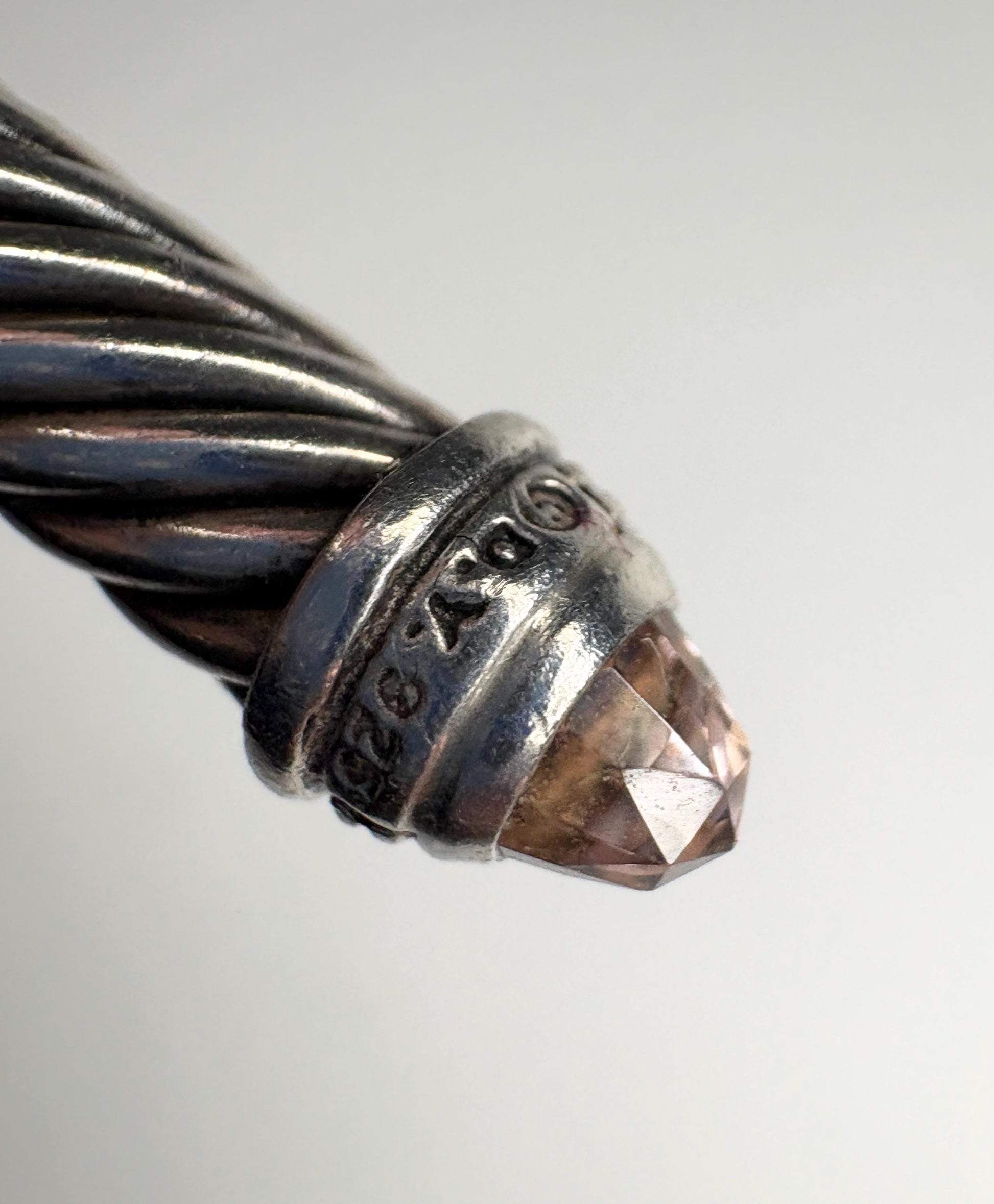 Sterling silver cable cuff bracelet with a faceted morganite-colored gemstone.