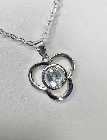 Sterling silver pendant necklace with a clover design and oval light blue tourmaline.
