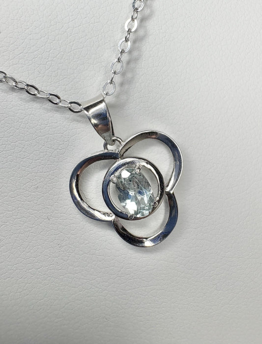Sterling silver pendant necklace with a clover design and oval light blue tourmaline.