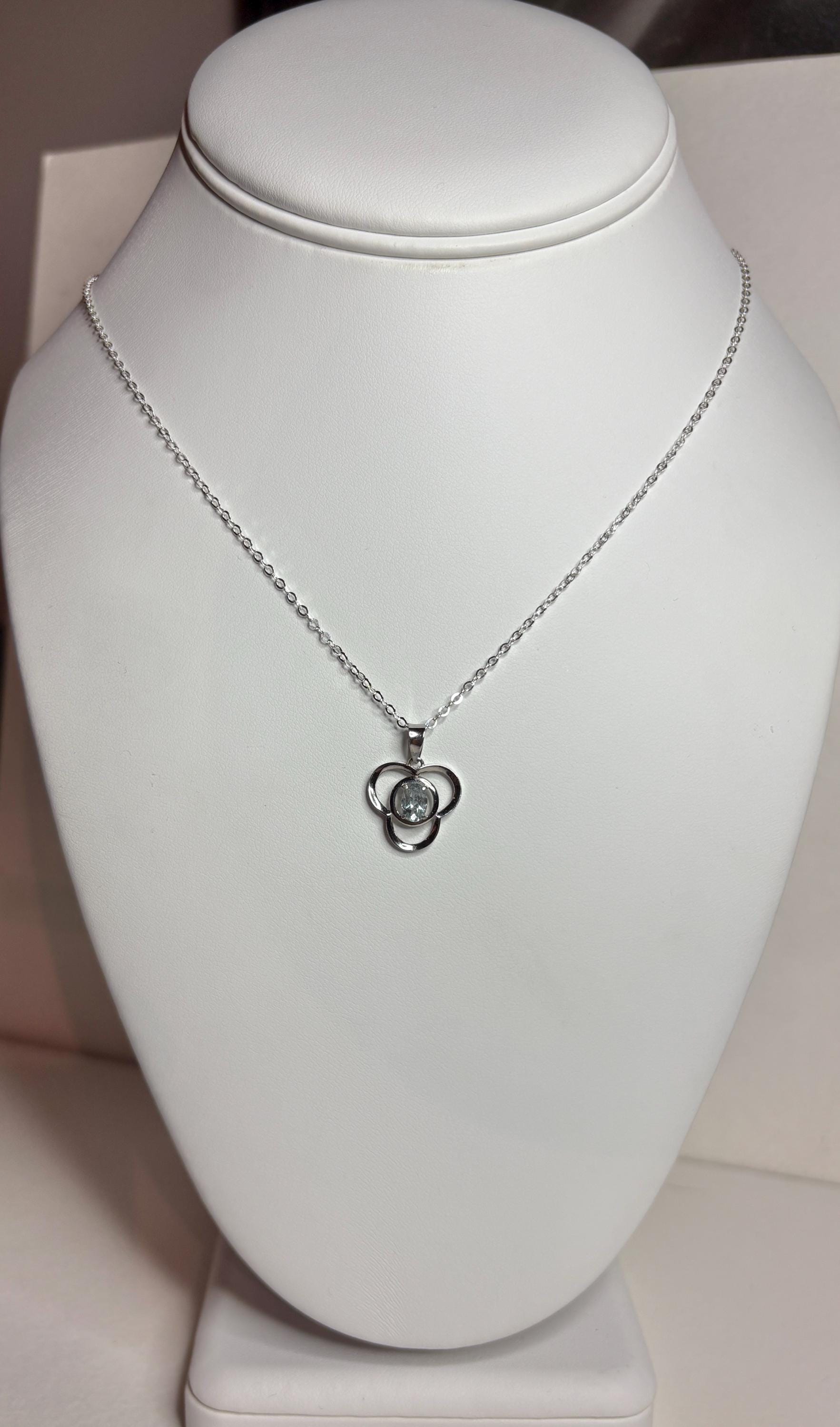 Sterling silver necklace with a clover pendant featuring a light blue oval tourmaline.