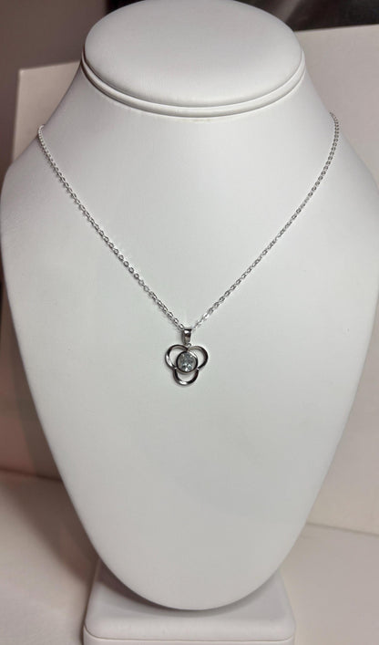 Sterling silver necklace with a clover pendant featuring a light blue oval tourmaline.