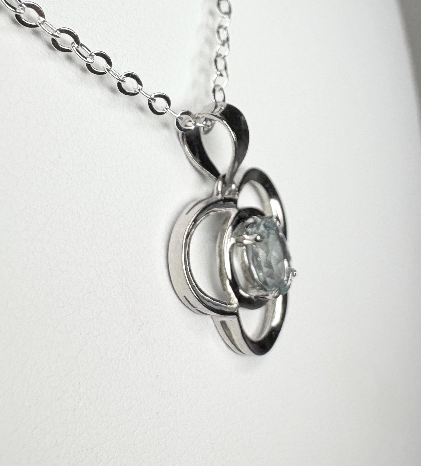 Sterling silver pendant necklace with a clover design and a light blue oval tourmaline.
