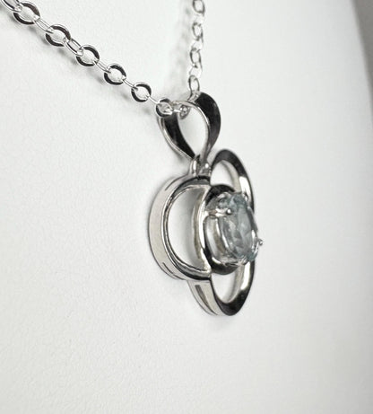 Sterling silver pendant necklace with a clover design and a light blue oval tourmaline.