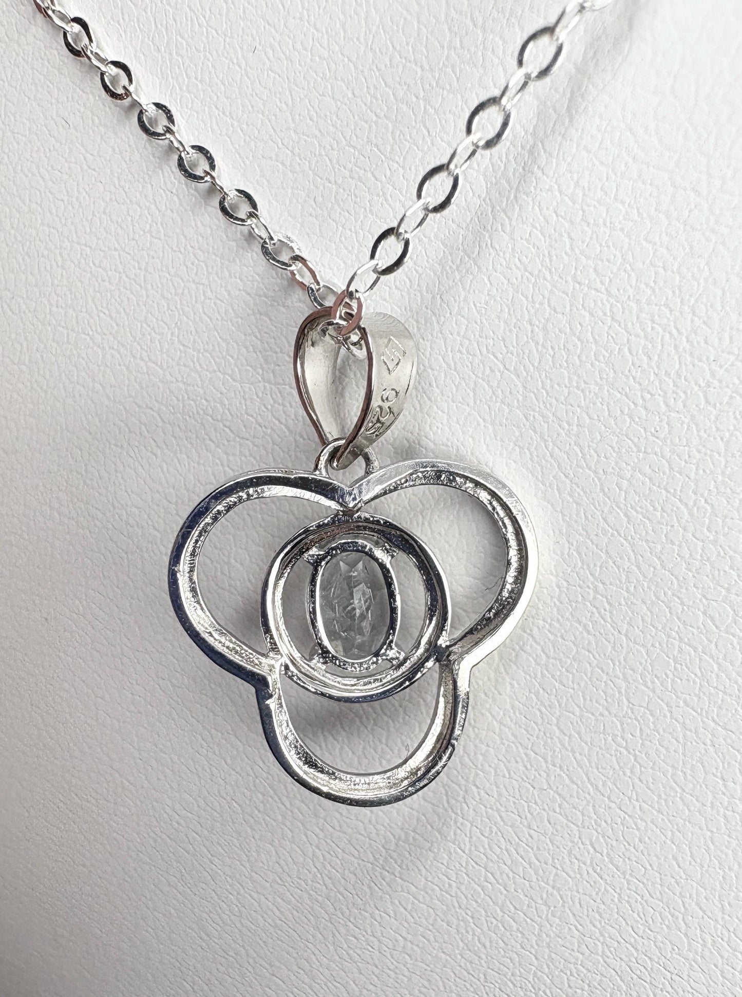 Sterling silver pendant necklace with a clover design and a light blue oval tourmaline.
