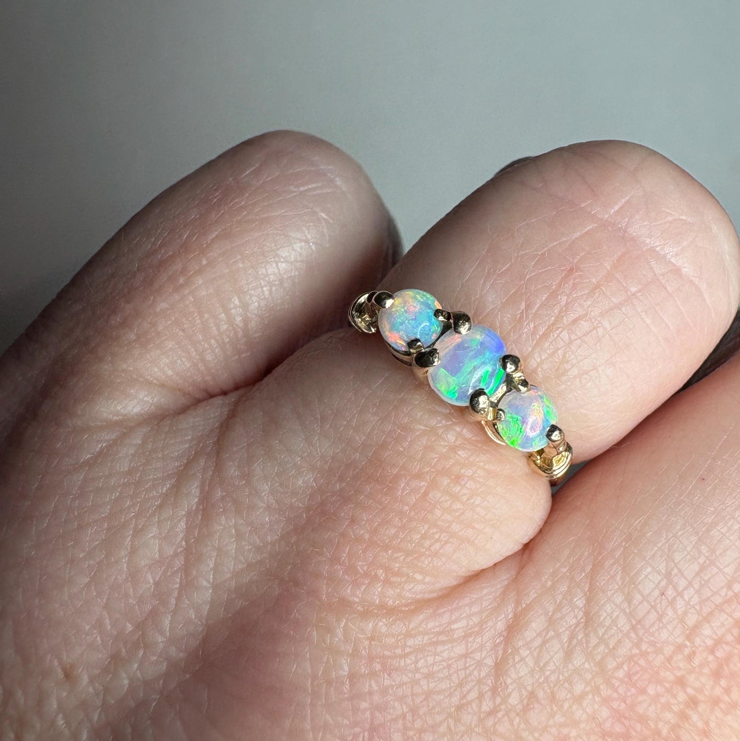 A 14k gold ring with three Australian opals.