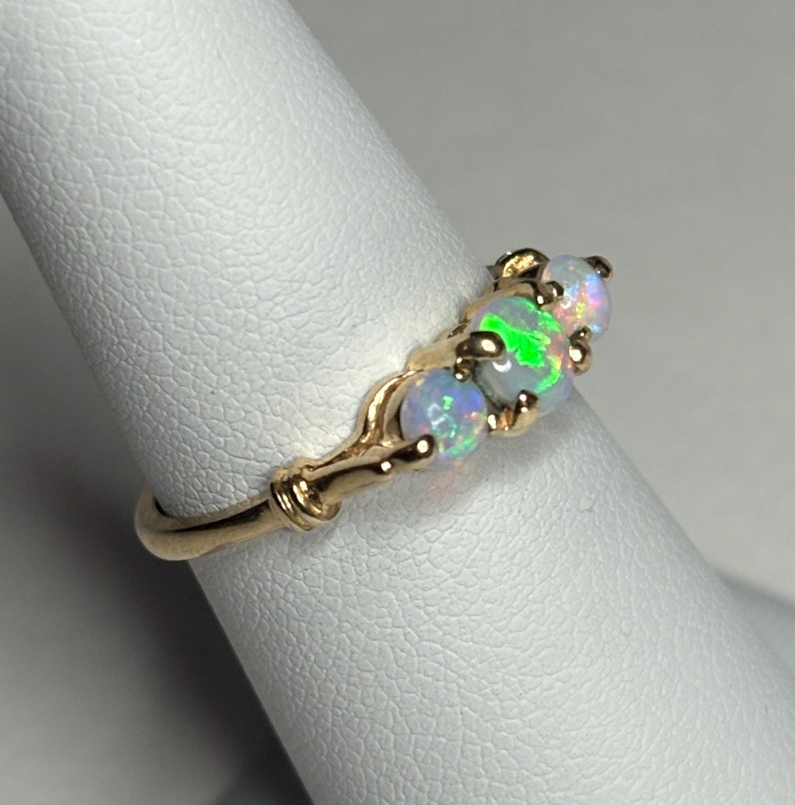 A 14k gold ring with three opals.