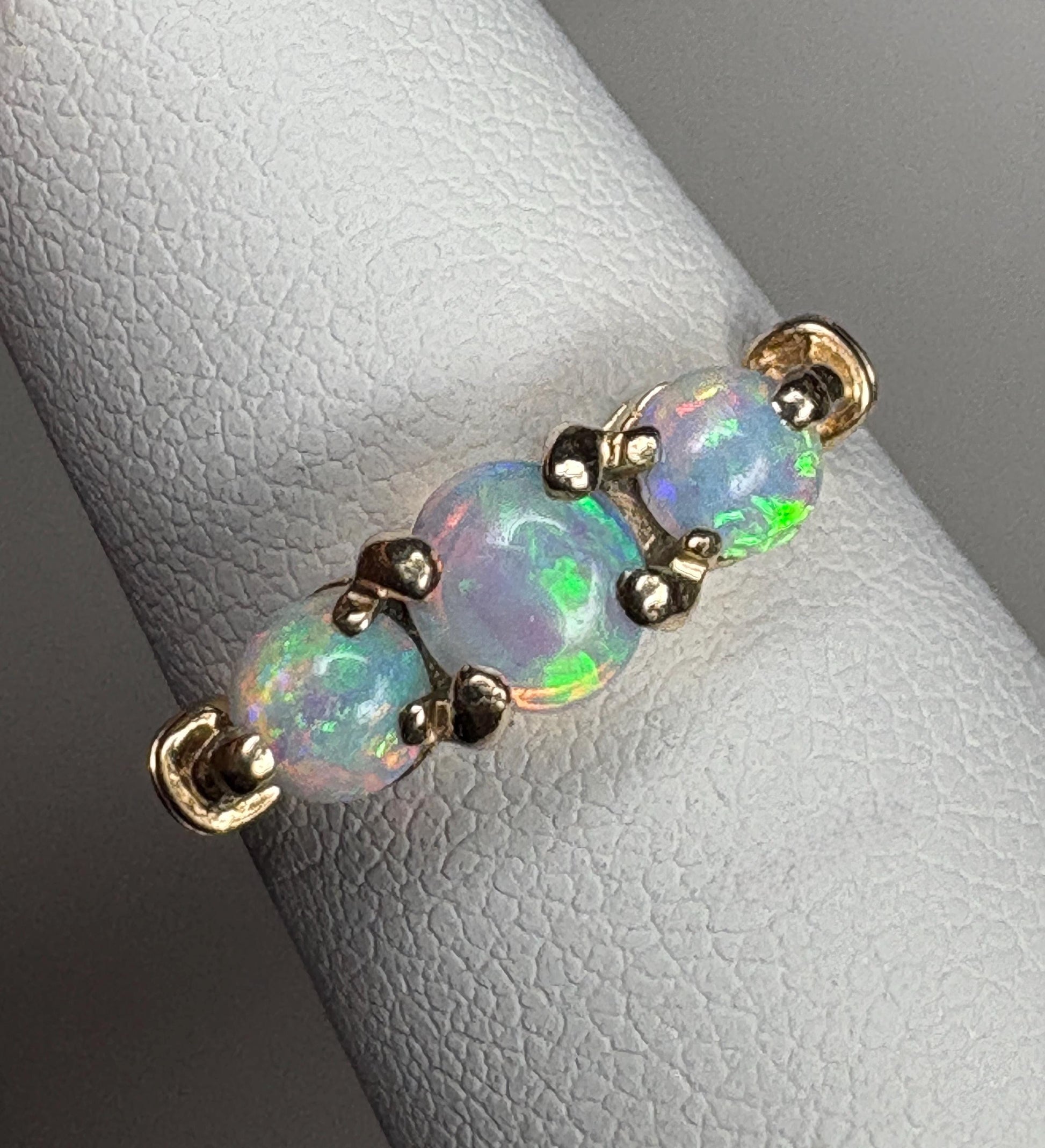 A 14k gold ring with three Australian opals.