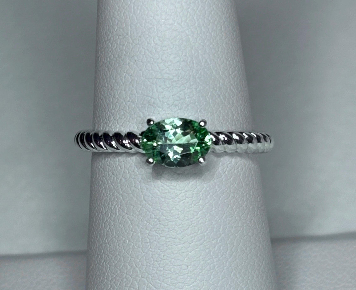 Sterling silver ring with an oval green tourmaline gemstone on a rope band.