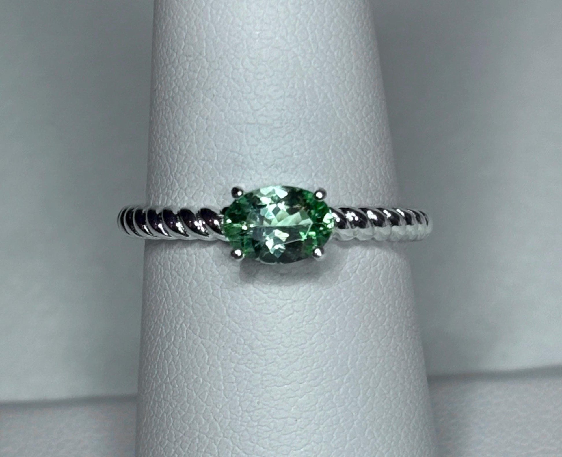 Sterling silver ring with an oval green tourmaline gemstone on a rope band.