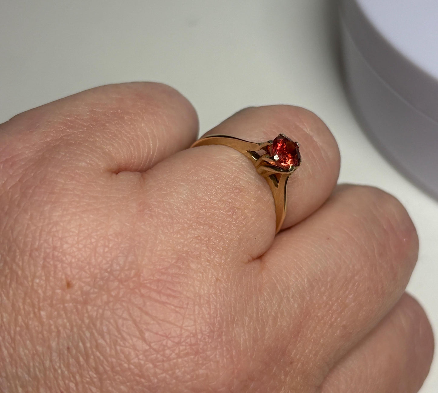 A red Oregon sunstone solitaire ring in 10k gold.