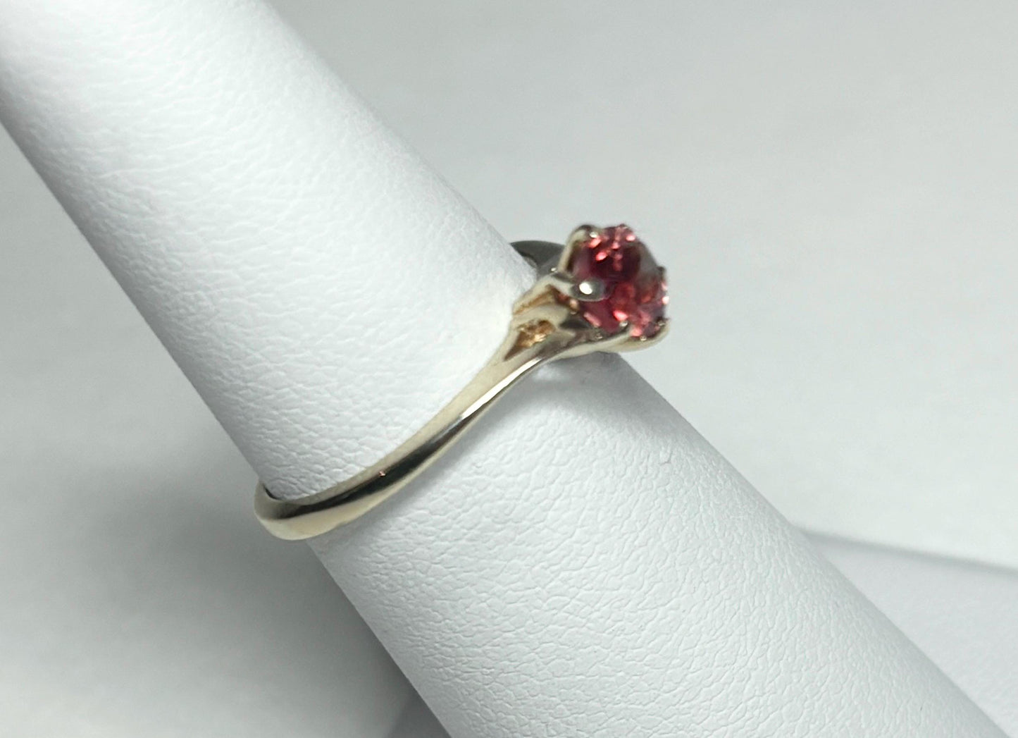 A red Oregon sunstone solitaire ring in 10k gold.