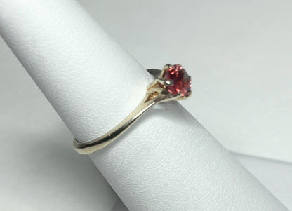 A red Oregon sunstone solitaire ring in 10k gold.