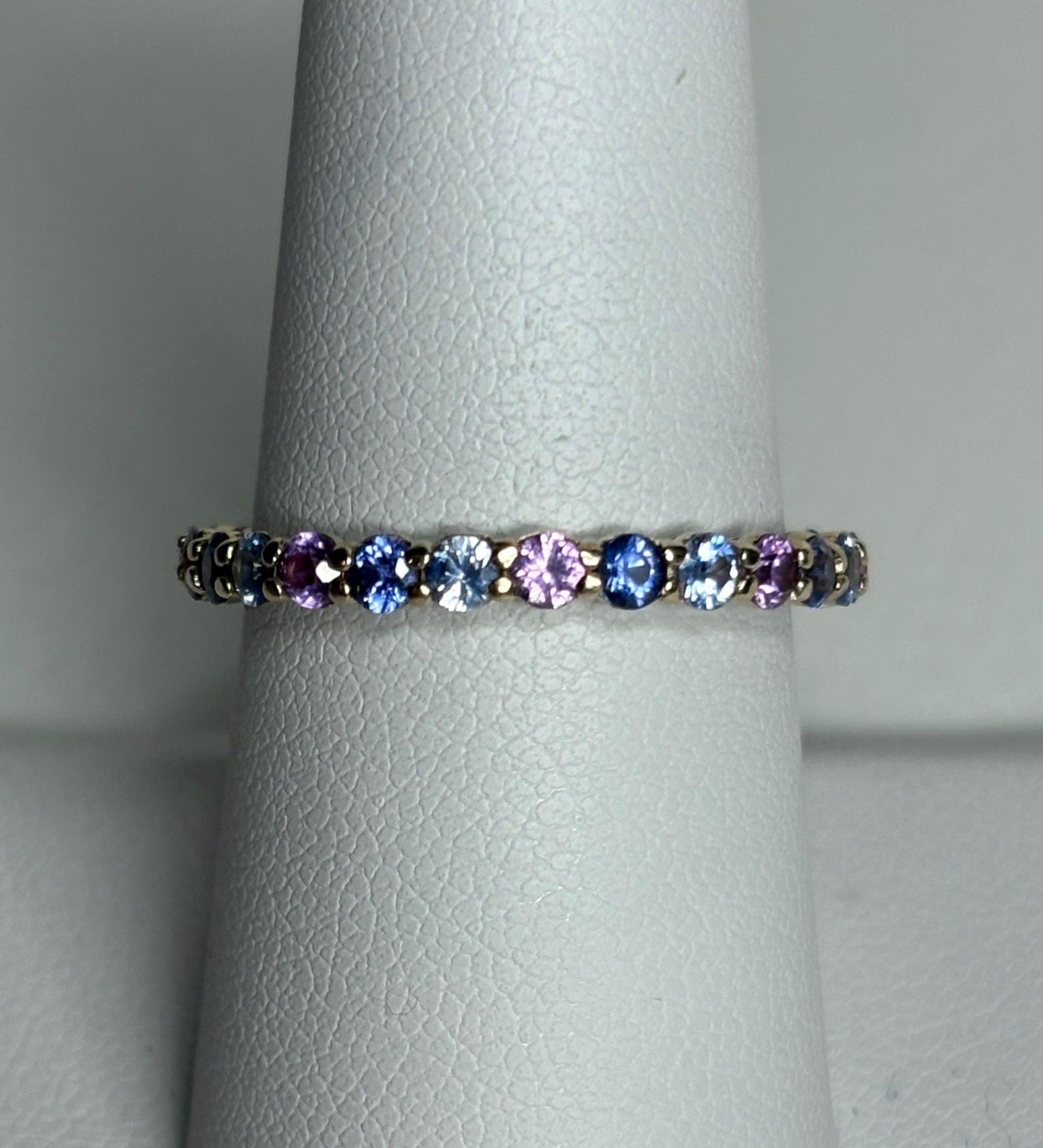 Multi-color sapphire full eternity band ring in 14k gold.