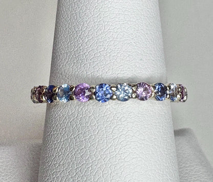 A 14k gold eternity band with multi-colored natural sapphires.