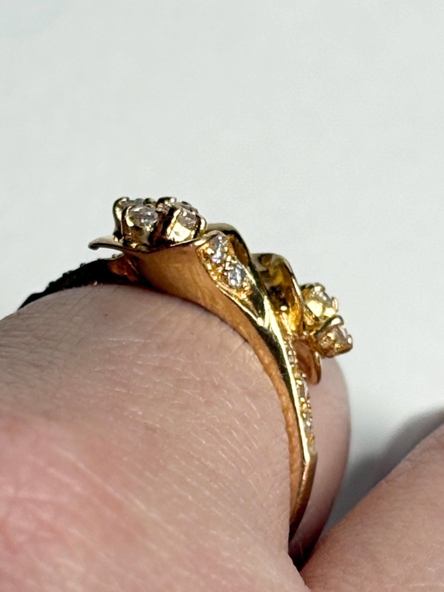 Solid 21k gold bypass ring with white stones.