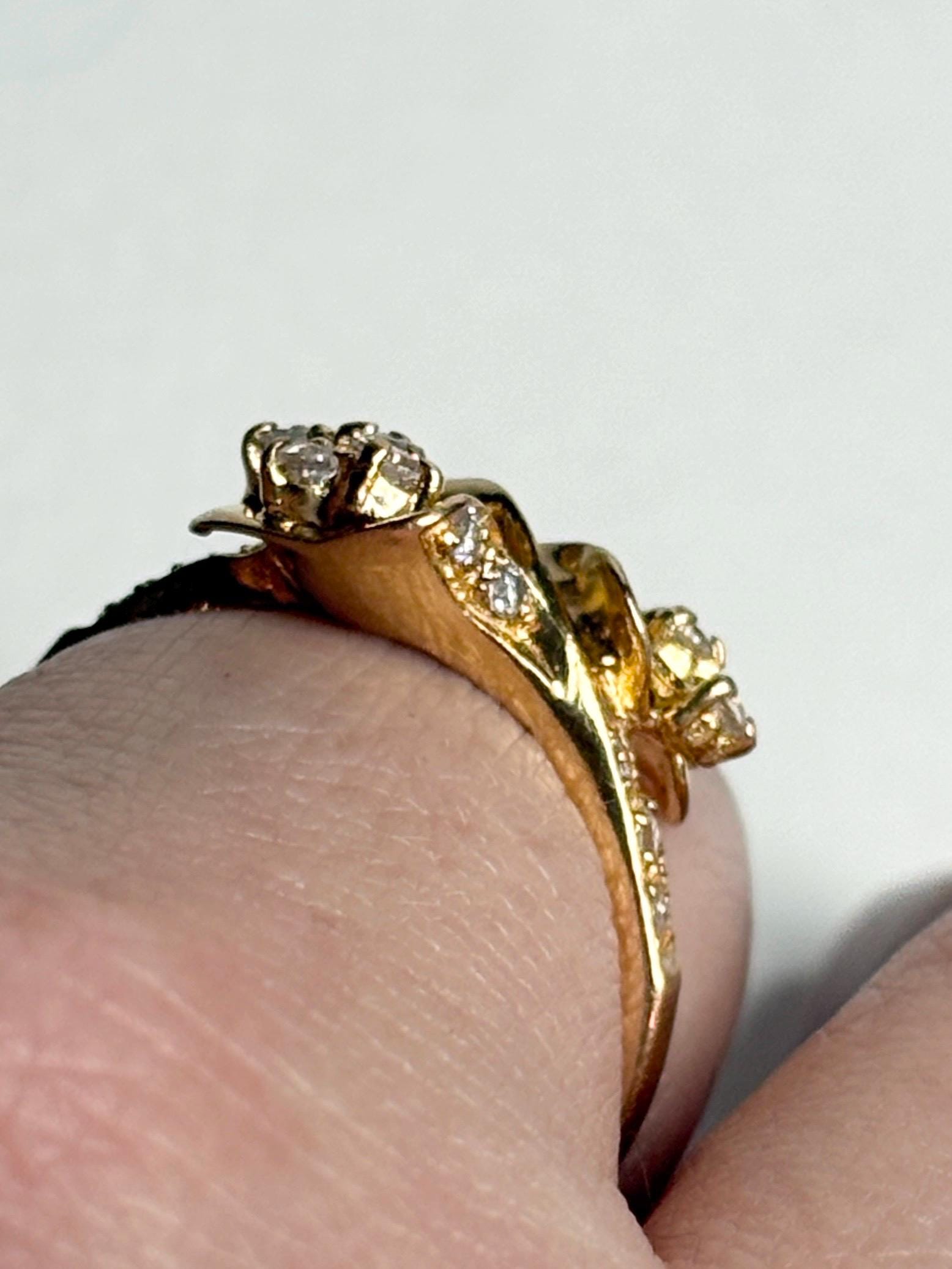 Solid 21k gold bypass ring with white stones.