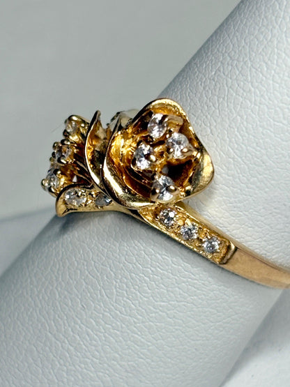 Solid 21k gold lily bypass ring with white stones.