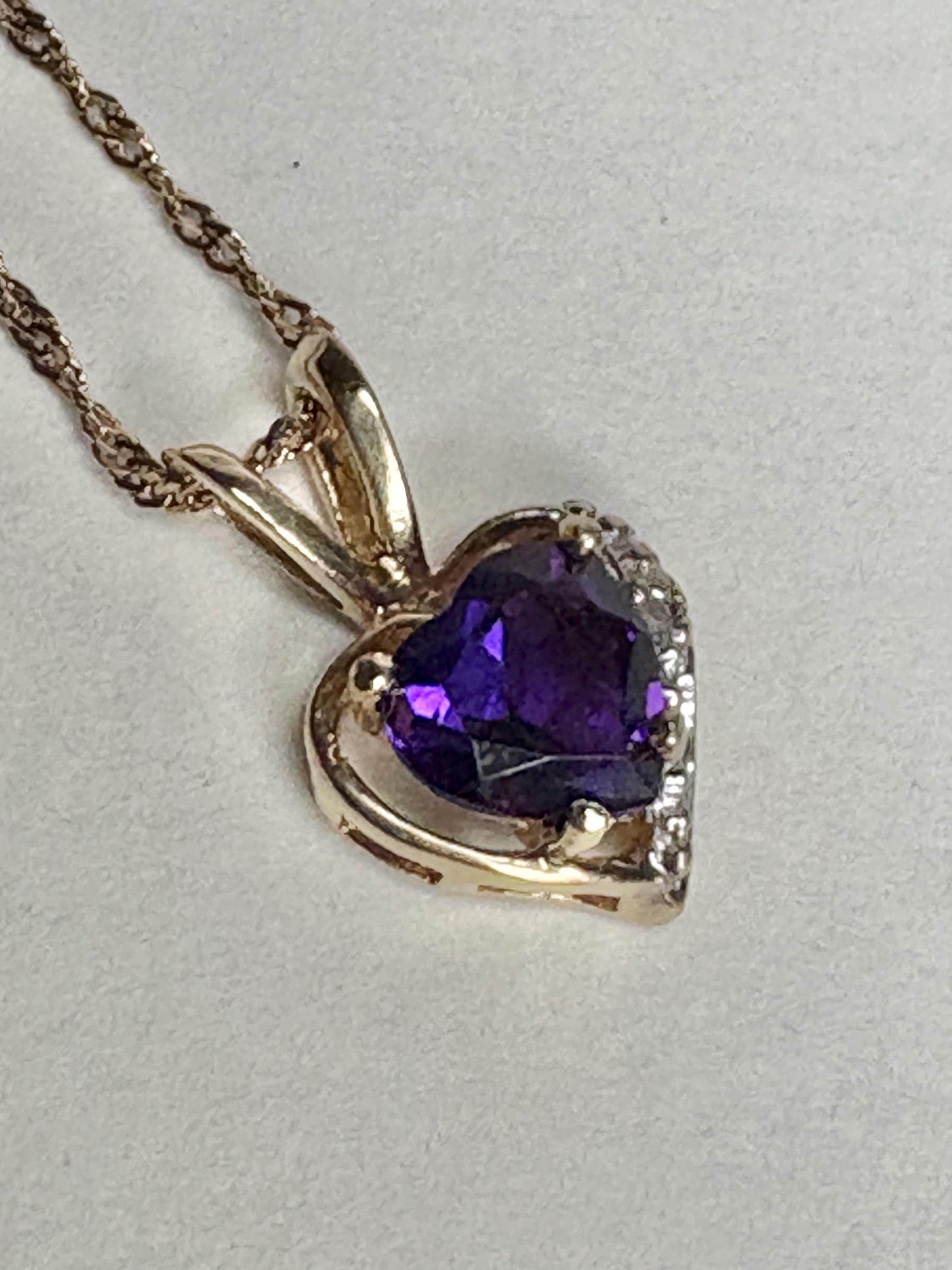 Heart-shaped amethyst and diamond pendant on a 14k gold chain.
