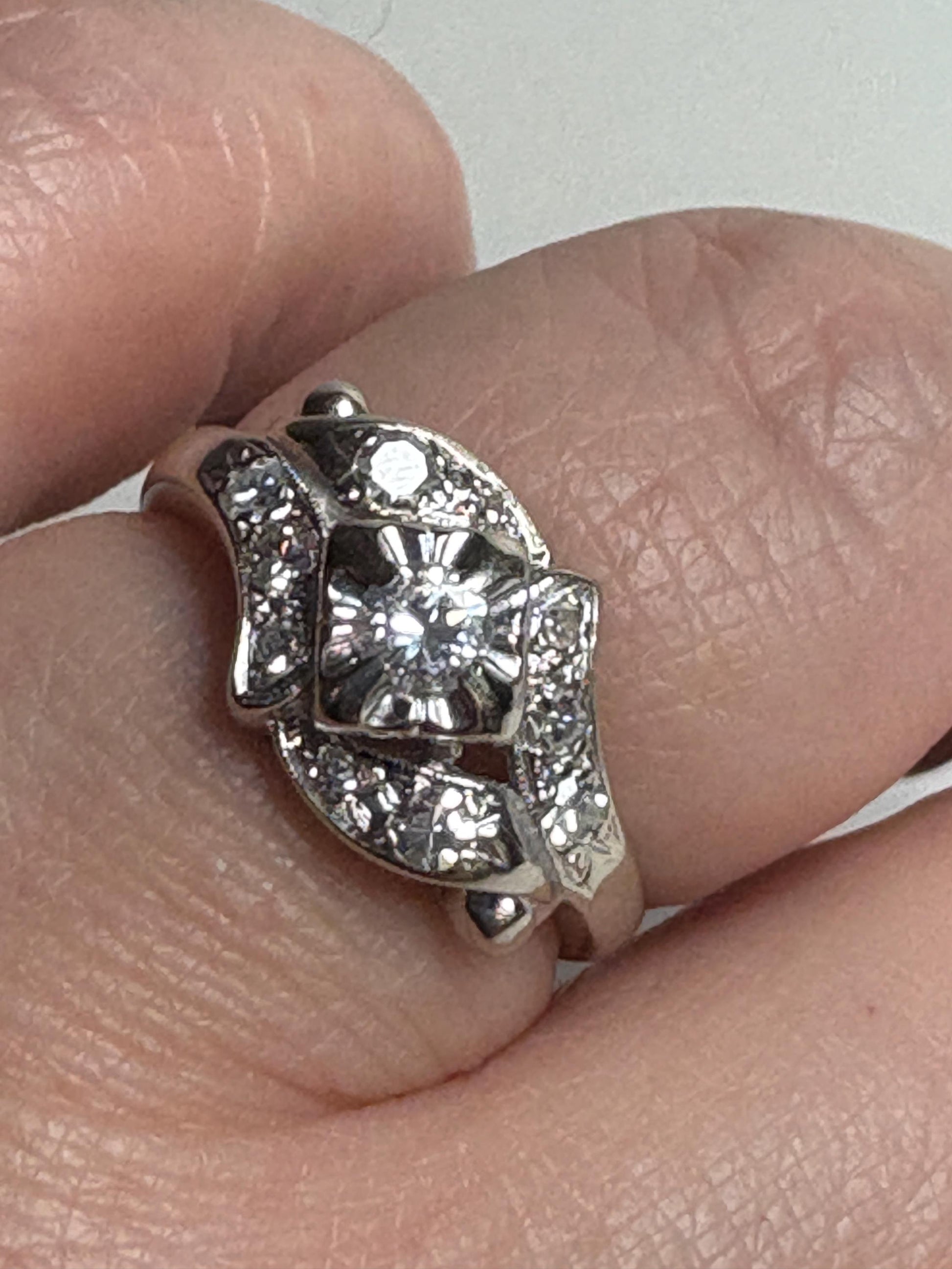 Vintage 14k white gold ring with a central diamond and surrounding single-cut diamonds.