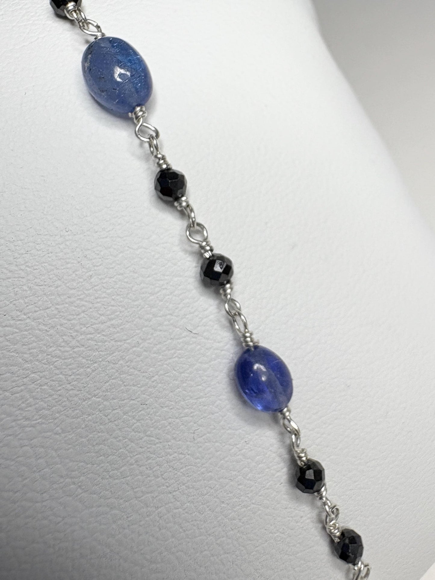 Sterling silver bracelet with oval tanzanite and faceted black diamond beads.