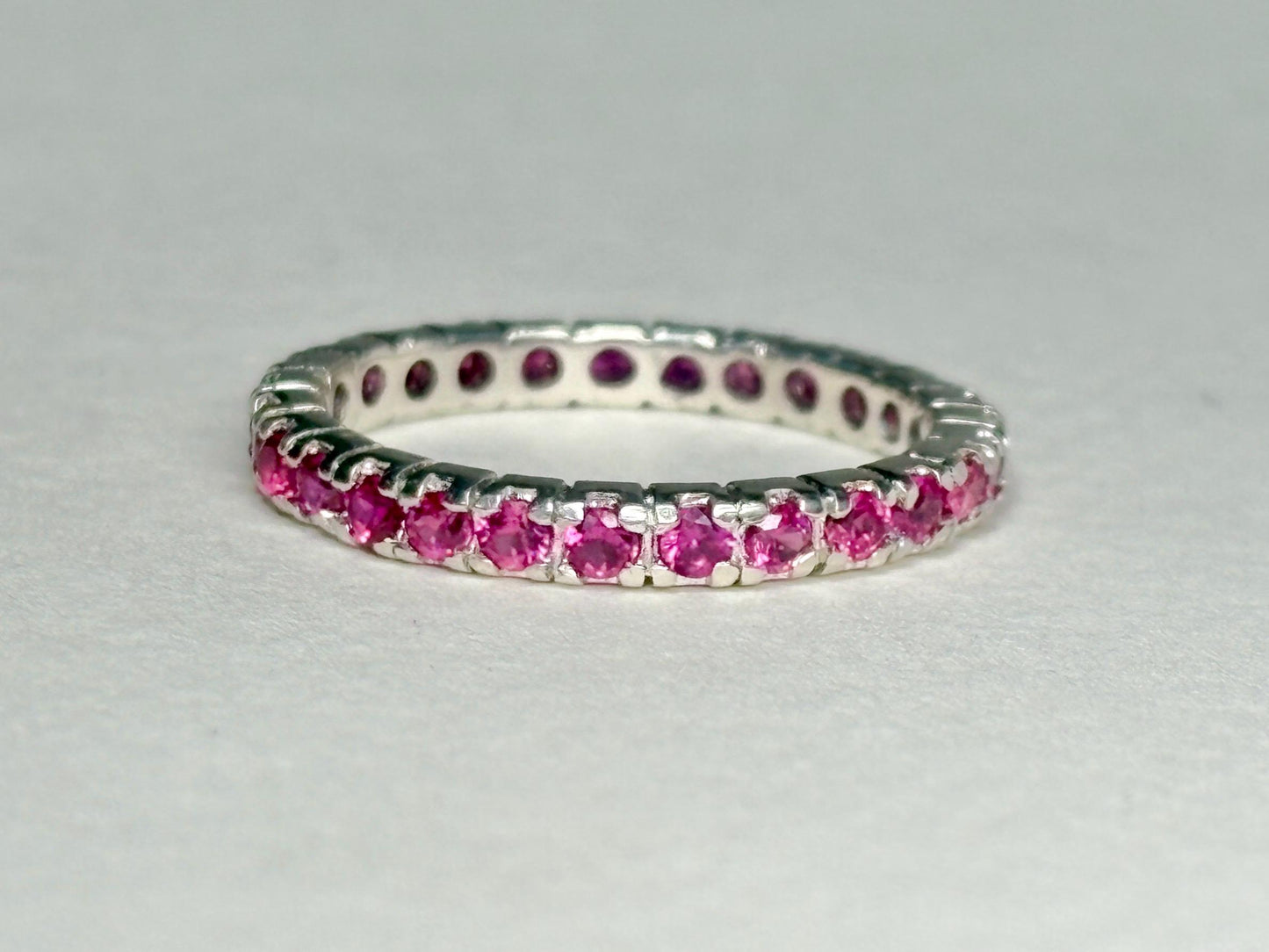 Hot pink lab-grown sapphire eternity ring in solid sterling silver.
