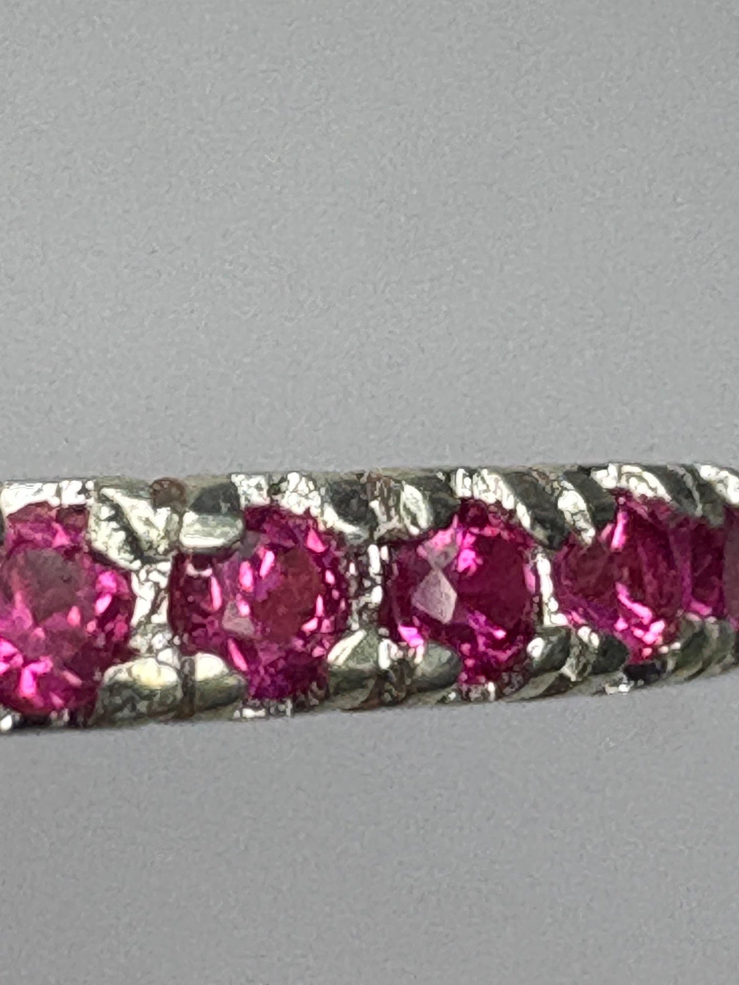 Hot pink lab-grown sapphire eternity ring in solid sterling silver.