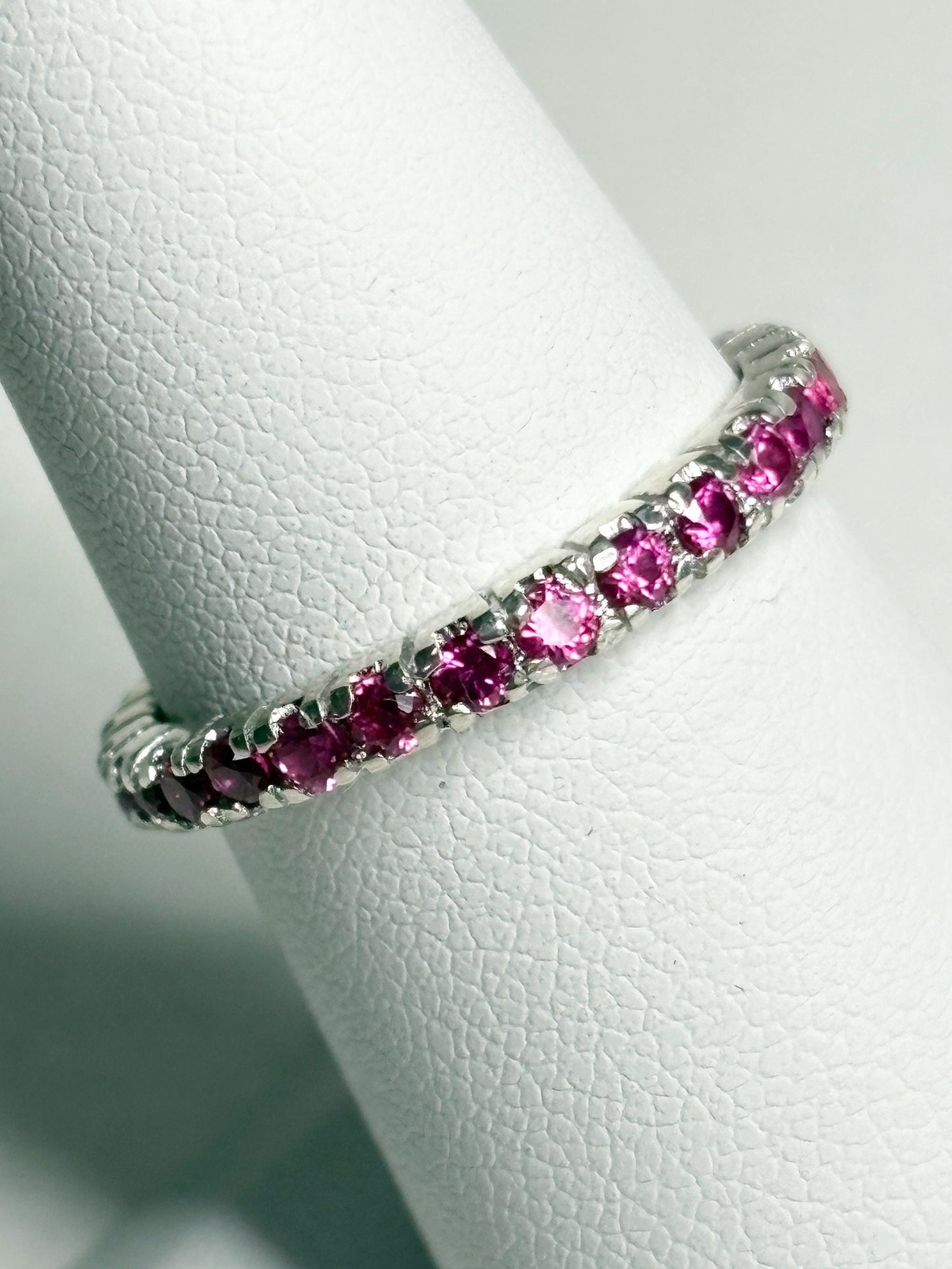 Hot pink lab-grown sapphire eternity ring in sterling silver.