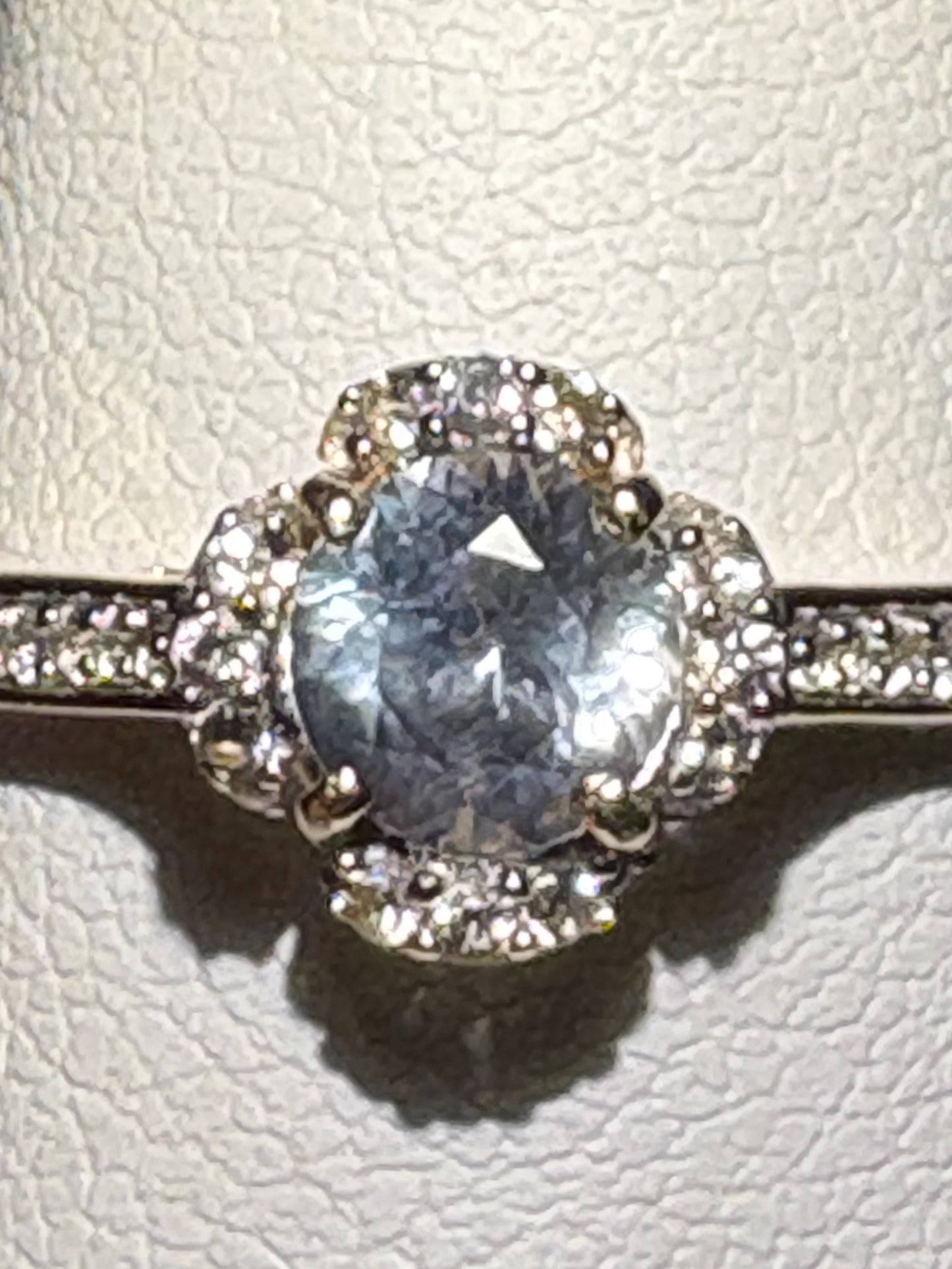 A light blue Montana sapphire floral halo ring with white zircon in 9k gold.