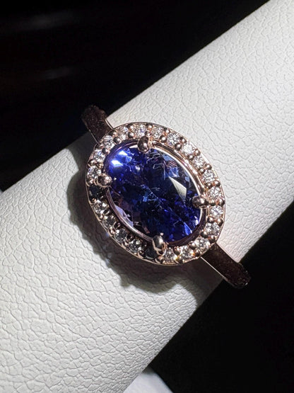 Oval tanzanite ring with diamond halo in rose gold.